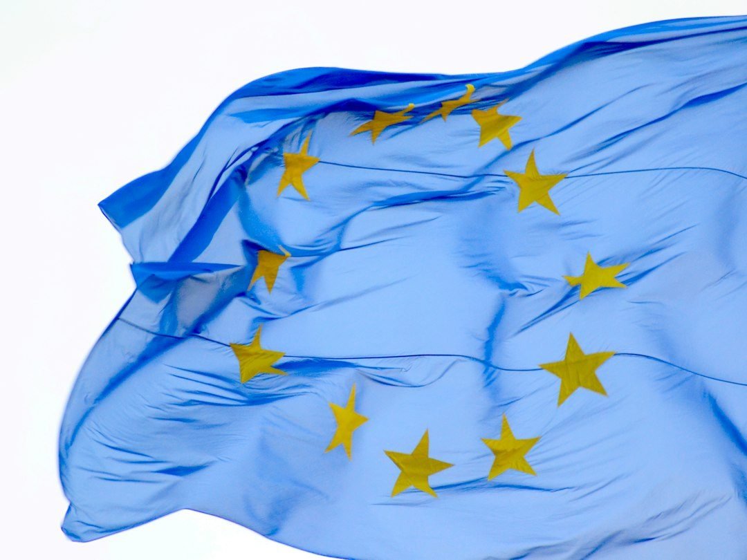European Union flag next to a laptop symbolizing corporate use of artificial intelligence
